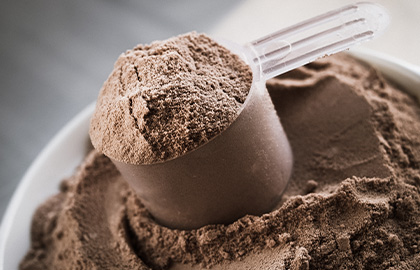 Um scoop de proteína bovina sabor cacau, seguro para quem tem restrições ao consumo de leite e seus derivados