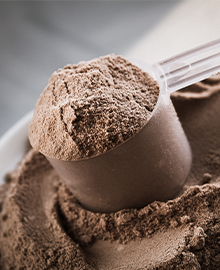 Um scoop de proteína bovina sabor cacau, seguro para quem tem restrições ao consumo de leite e seus derivados