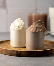 Dois scoops de proteína bovina em um prato de madeira, exibindo suas texturas e cores distintas