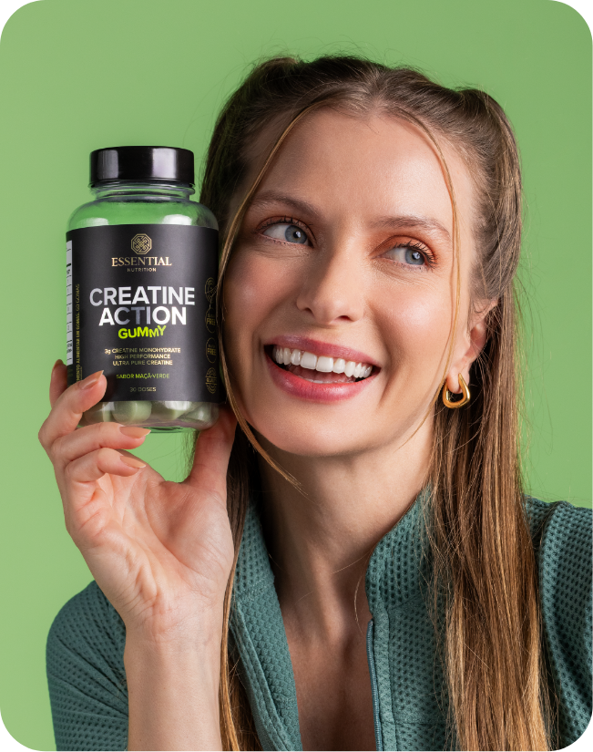Mulher sorrindo segurando um pote de creatine action gummy sabor maçã verde.