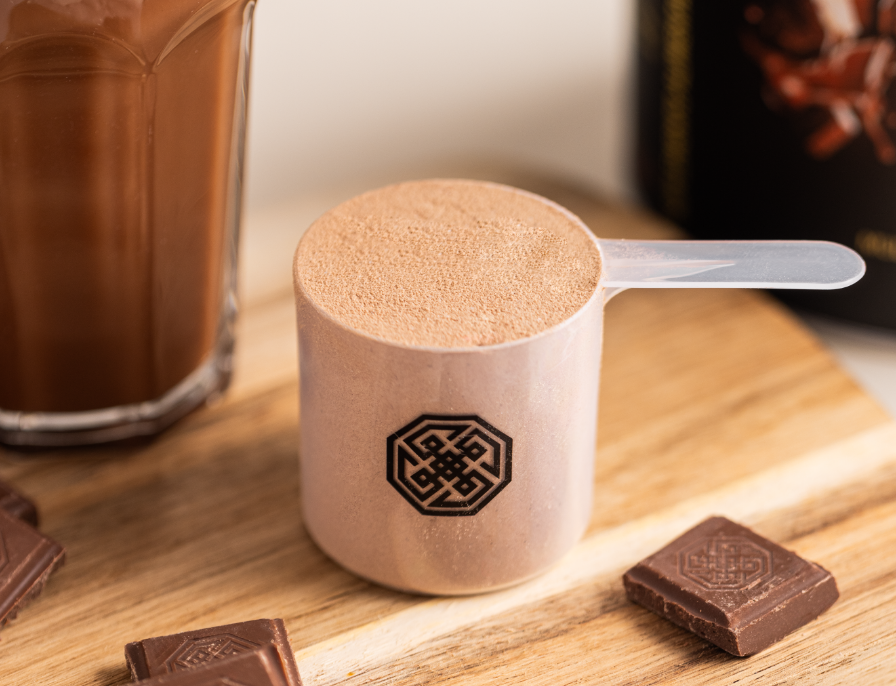foto de um scoop do beef protein cacao com um chocolate belga da essential nutrition ao lado