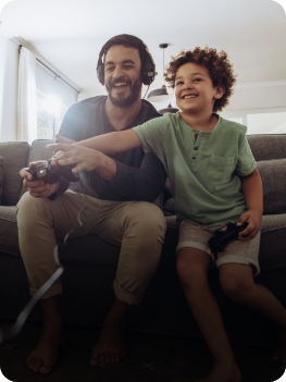 Um homem e um garoto se divertindo enquanto jogam videogame, compartilhando momentos de diversão e conexão.