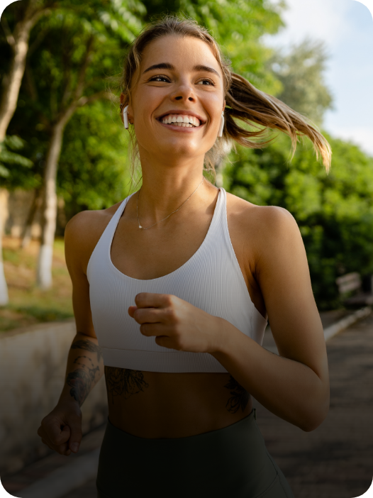 mulher sorrindo enquanto corre ao ar livre e com a imunidade em dia
